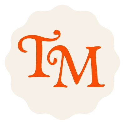 Orange TM monogram on a cream scalloped badge