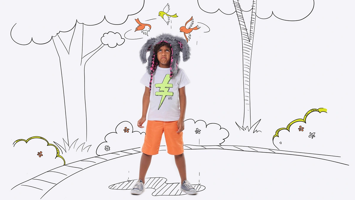 Child in a furry hat surrounded by illustrated trees and birds